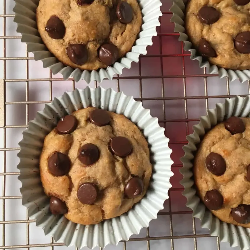 Kodiak Cakes protein muffins with chocolate chips cooling on a rack.