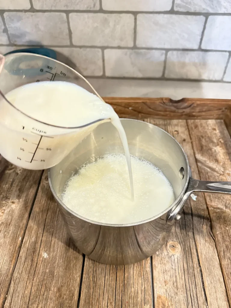 Pouring milk into a saucepan for the hot cocoa.