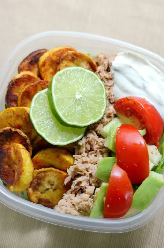 A tuna meal prep bowl with vegetables on a table.