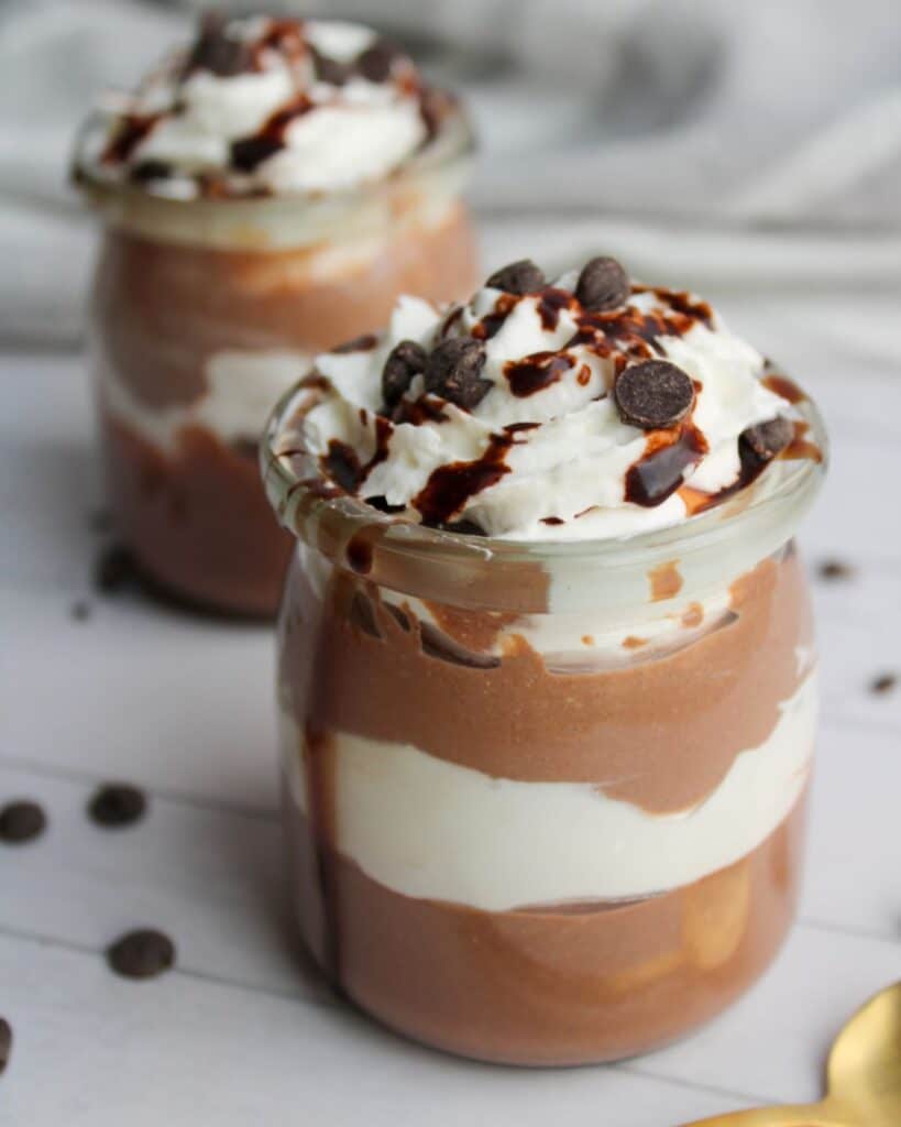 Two jars of high protein chocolate pudding made with cottage cheese on a counter.