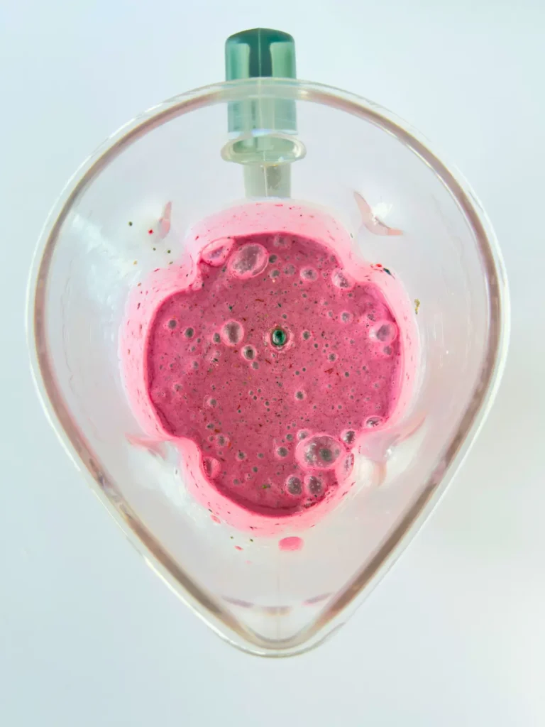 Pureed banana berry smoothie in a blender.