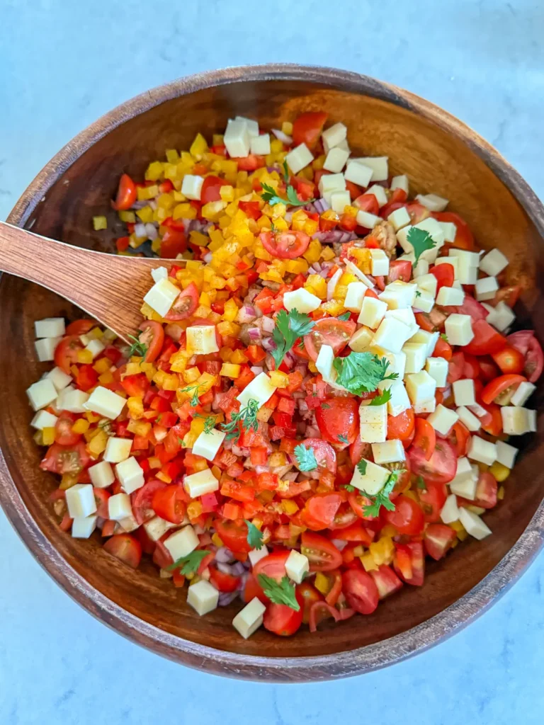 Stirring the dressing into a large bowl of dense bean salad.