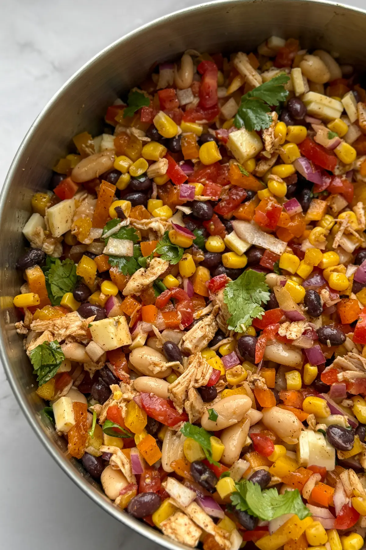 A left sided image of a bowl of dense bean salad .