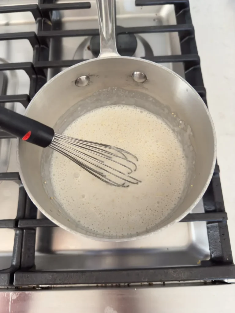 Whisking together the quinoa bowl base in a pan on the stove.