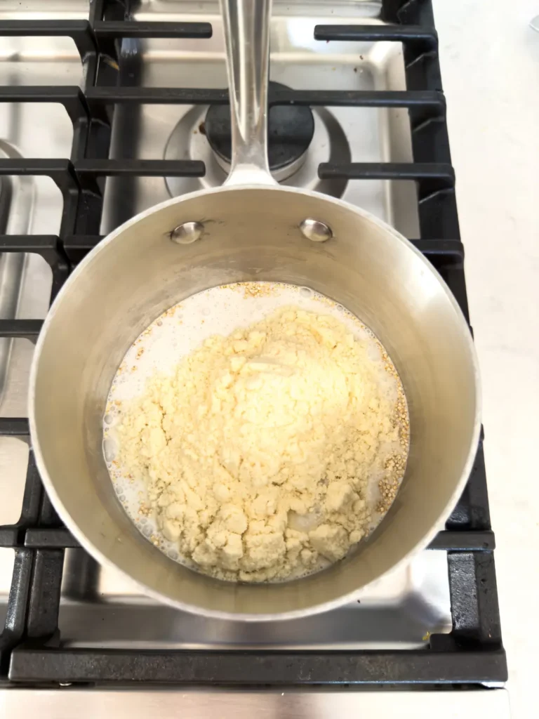 The base ingredients for the quinoa breakfast bowl in a pot on the stove.