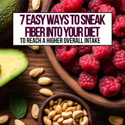 A large bowl of raspberries next to a half of an avocado and a bowl of peanuts on a table.