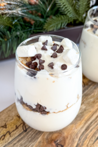 A large glass of s'mores Greek yogurt topped with marshmallow cream and mini chocolate chips.