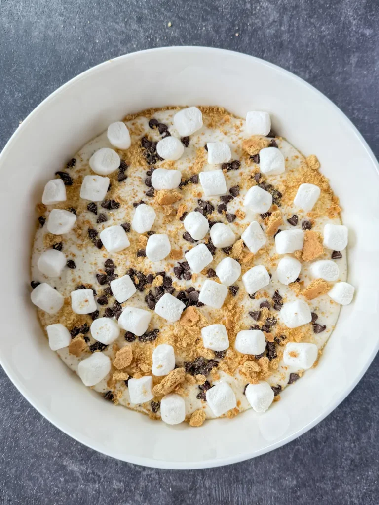 Adding mini marshmallows and crushed graham crackers to the s'mores dip with mini chocolate chips.