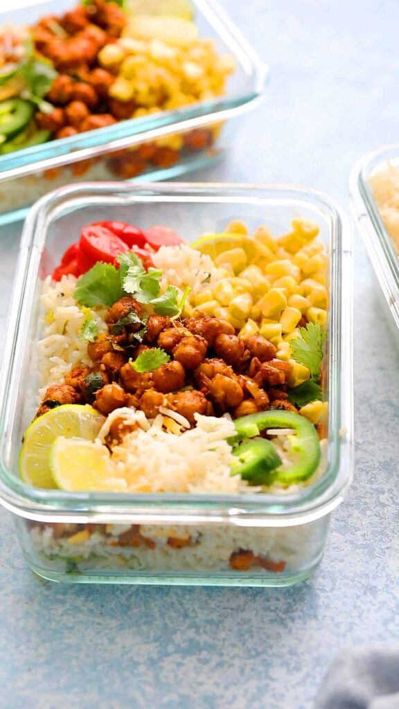 Mexican chickpeas, corn, rice, veggies and cheese in a meal prep container on the counter. 