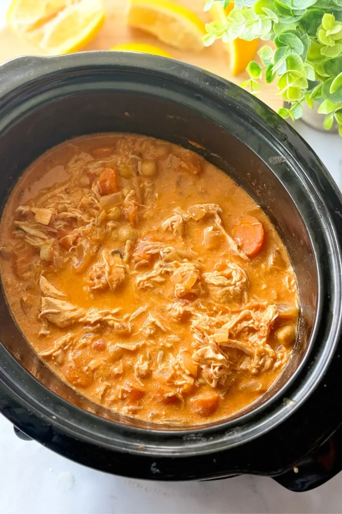 A birds-eye view of the cooked carrots, onions and chickpeas in a crockpot on a counter.