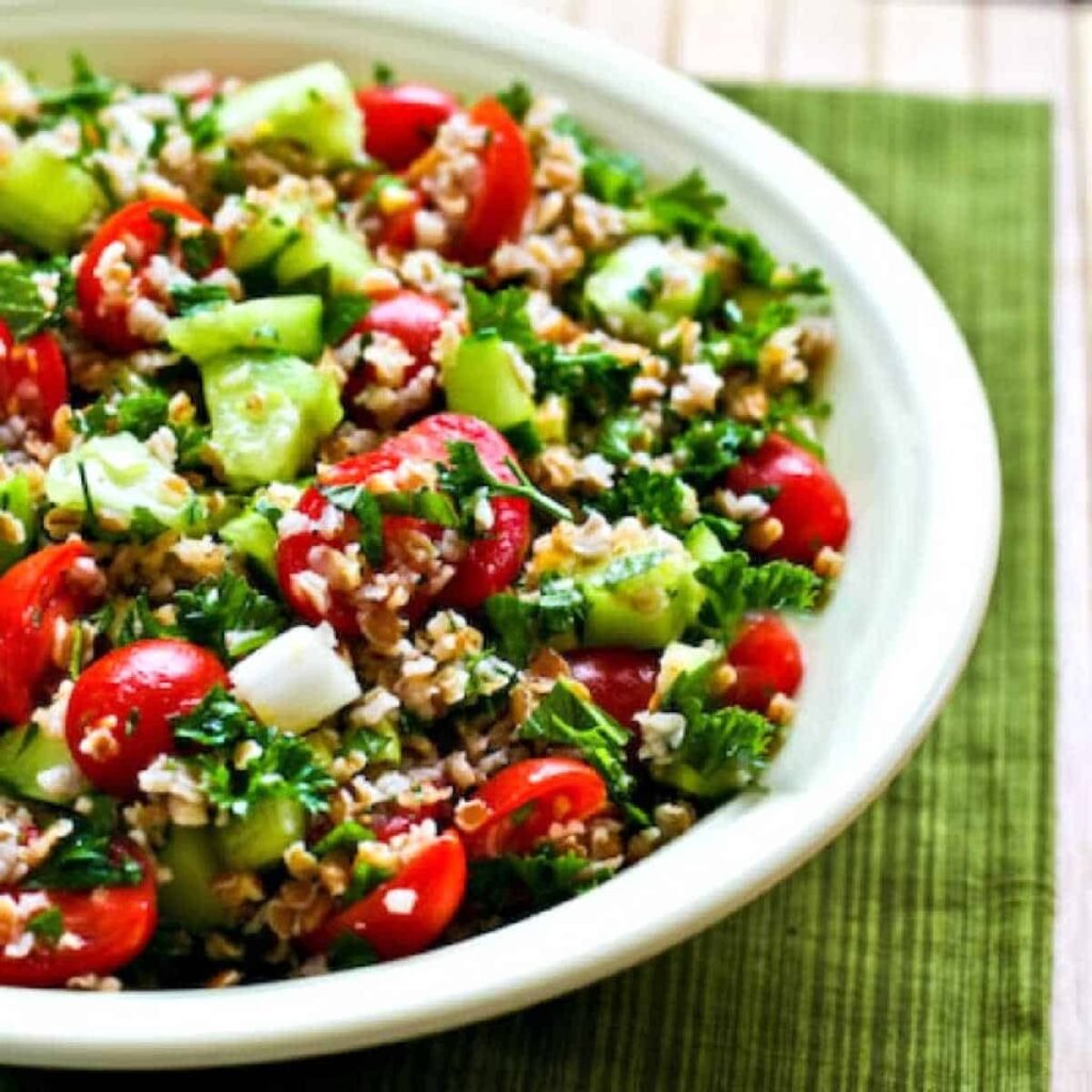 A bulgur wheat salad with cucumbers and tomatoes on a plate.