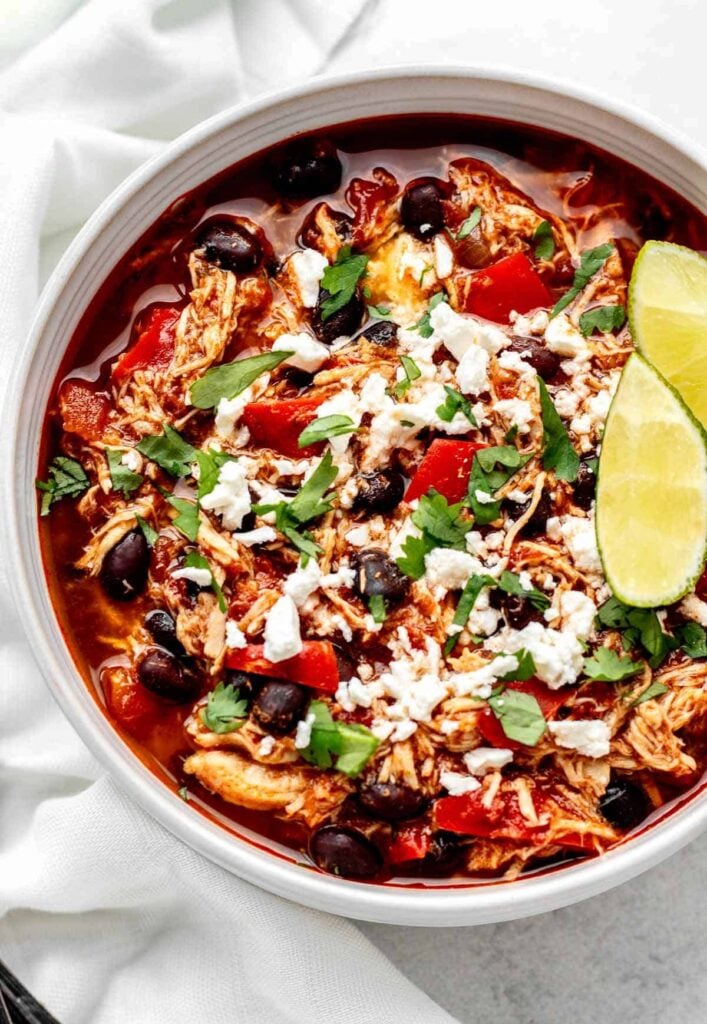 A big bowl of buffalo chicken chili garnished with a lime. 