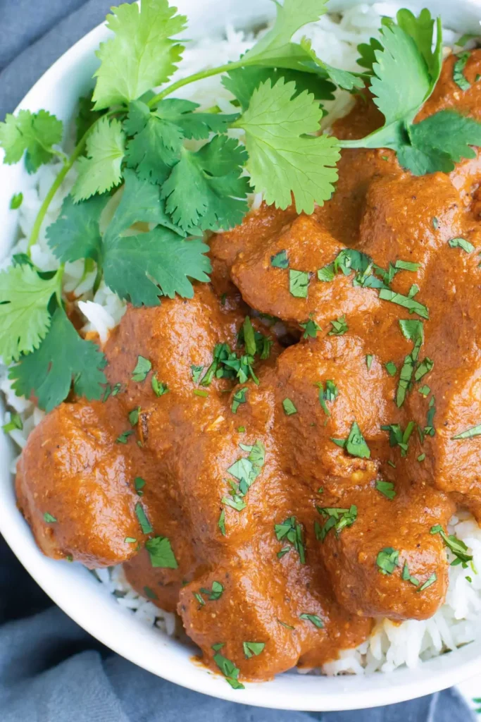 Chicken Tikka masala on a plate with fresh herbs.