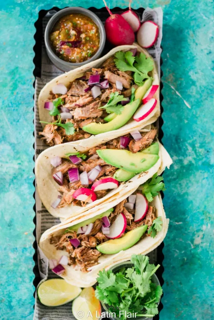 Pork carnitas lined up on a platter on a table.