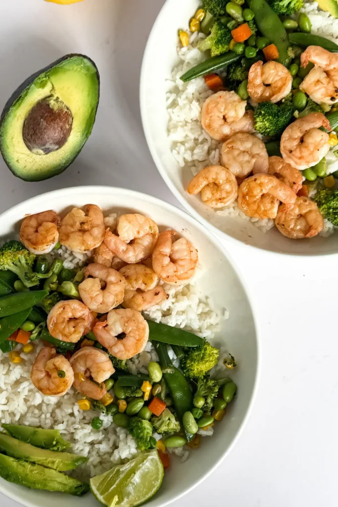 A birds-eye view of fully assembled shrimp and rice bowls without the drizzled sauces on them yet.