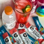 A birds-eye view of different electrolyte supplements with a glass of Liquid IV on a counter.