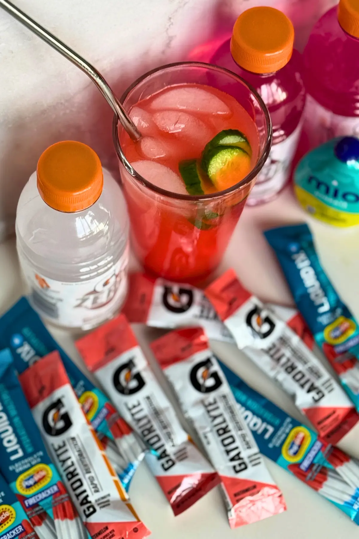 A birds-eye view of different electrolyte supplements with a glass of Liquid IV on a counter.