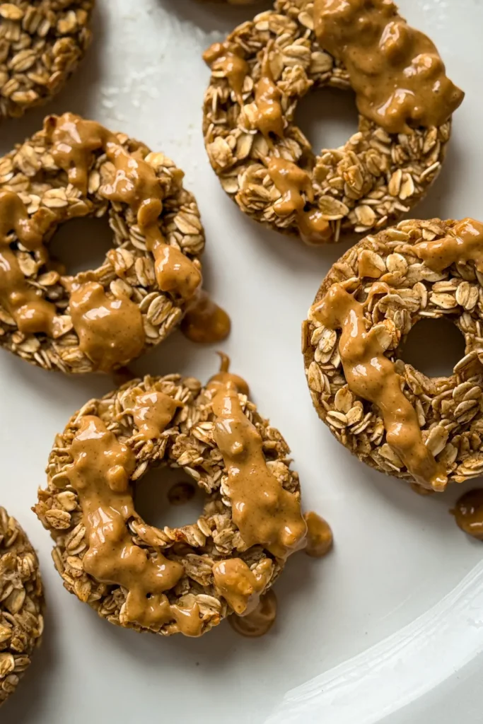 A birds-eye view of baked donuts lined up on a white platter.