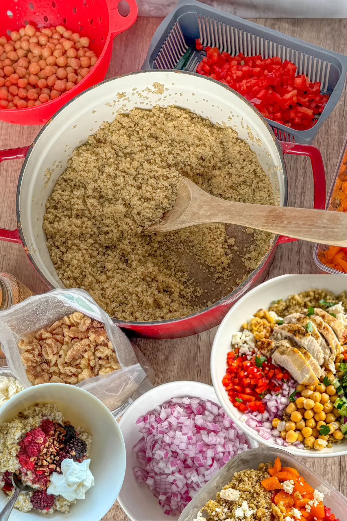 A pot of quinoa next to a Mediterranean power bowl and a coconut milk quinoa breakfast bowl on a counter.