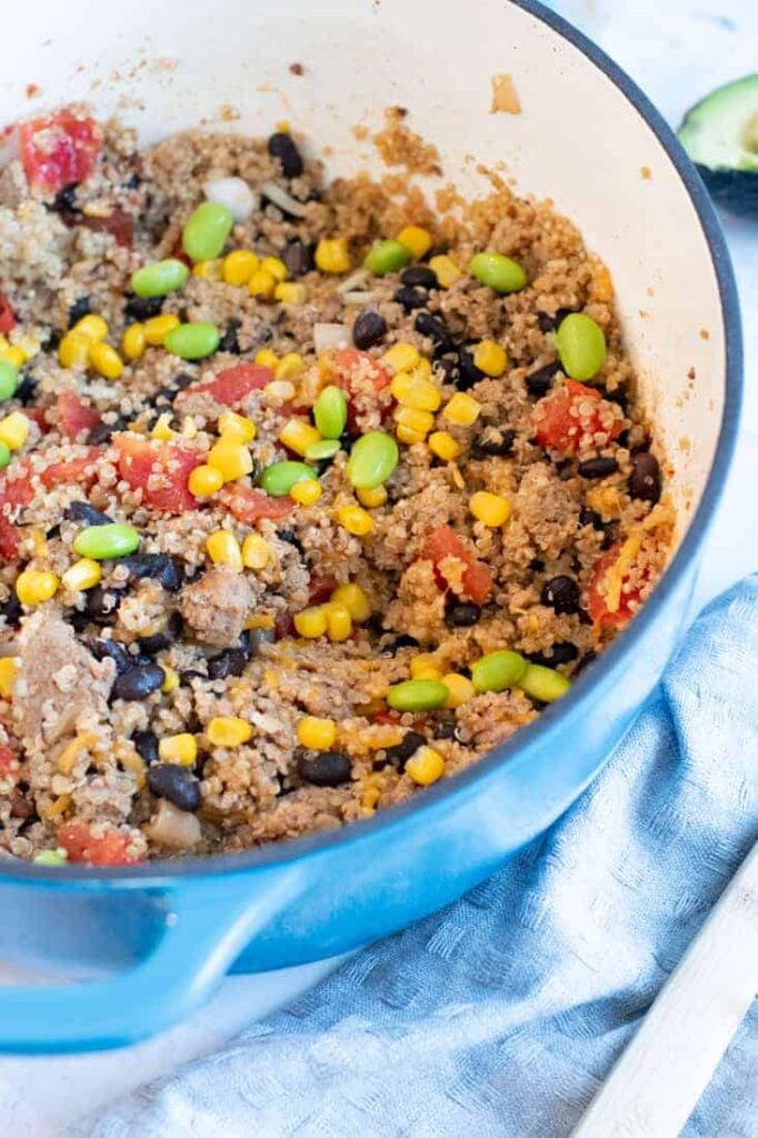 Ground turkey with quinoa and beans in a skillet on a towel on a table.