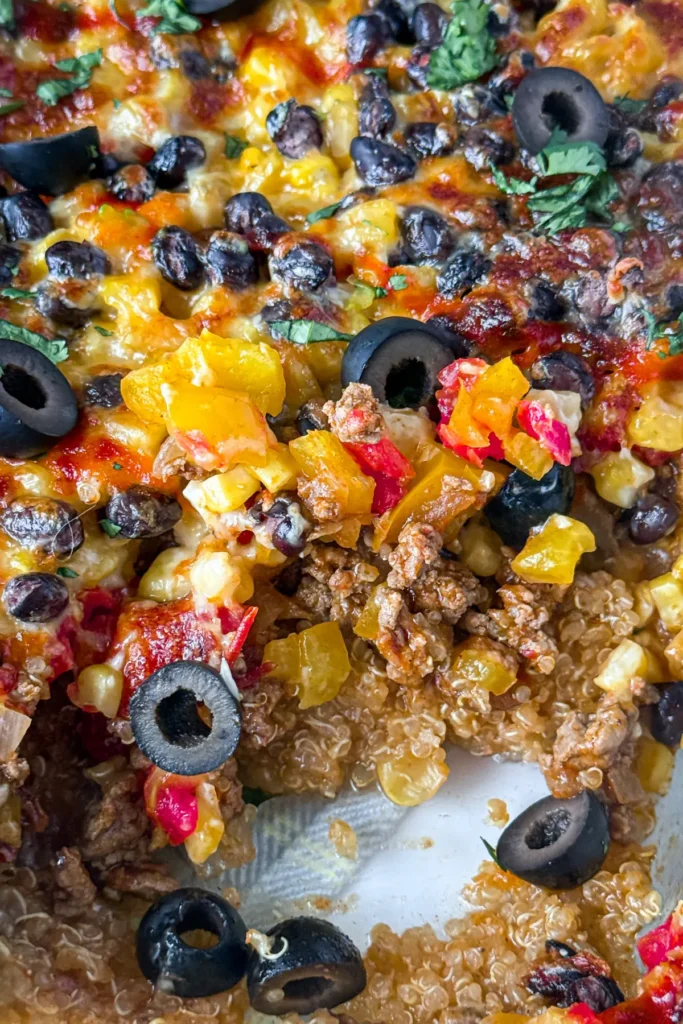 A close-up of the baked Mexican quinoa casserole with a slice taken out of it.