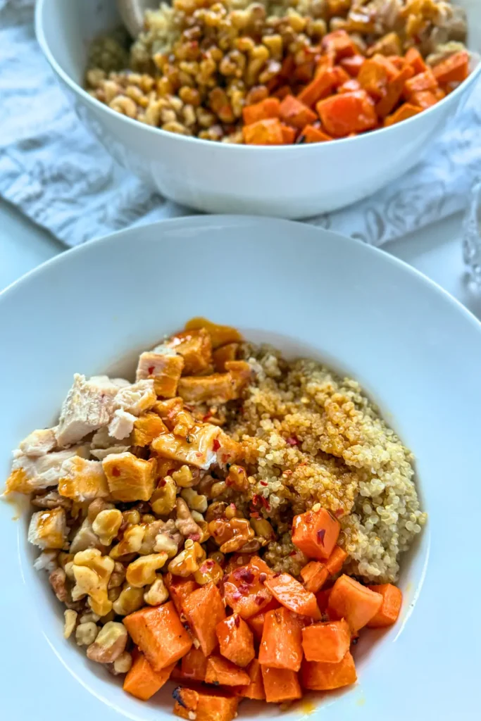 A sweet potato, chicken and quinoa bowl on a table.