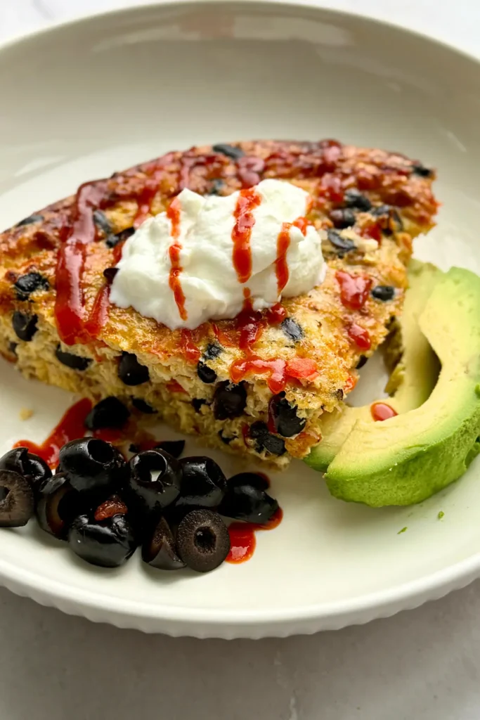 A quinoa breakfast bake topped with Greek yogurt on a plate.