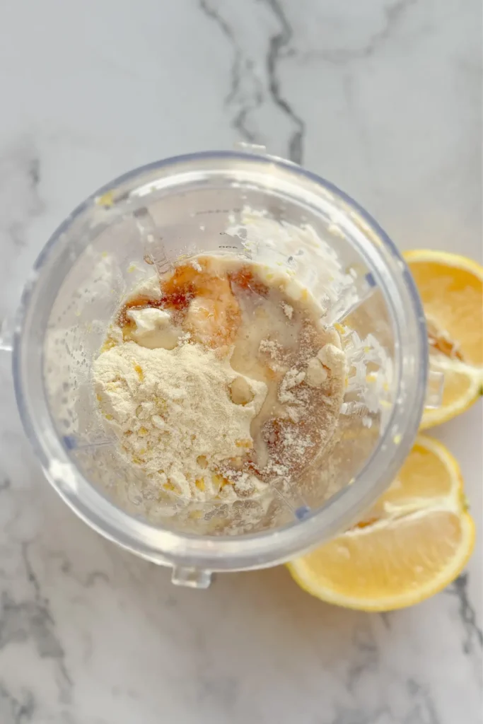 The ingredients for the protein whip in a blender cup on a counter.