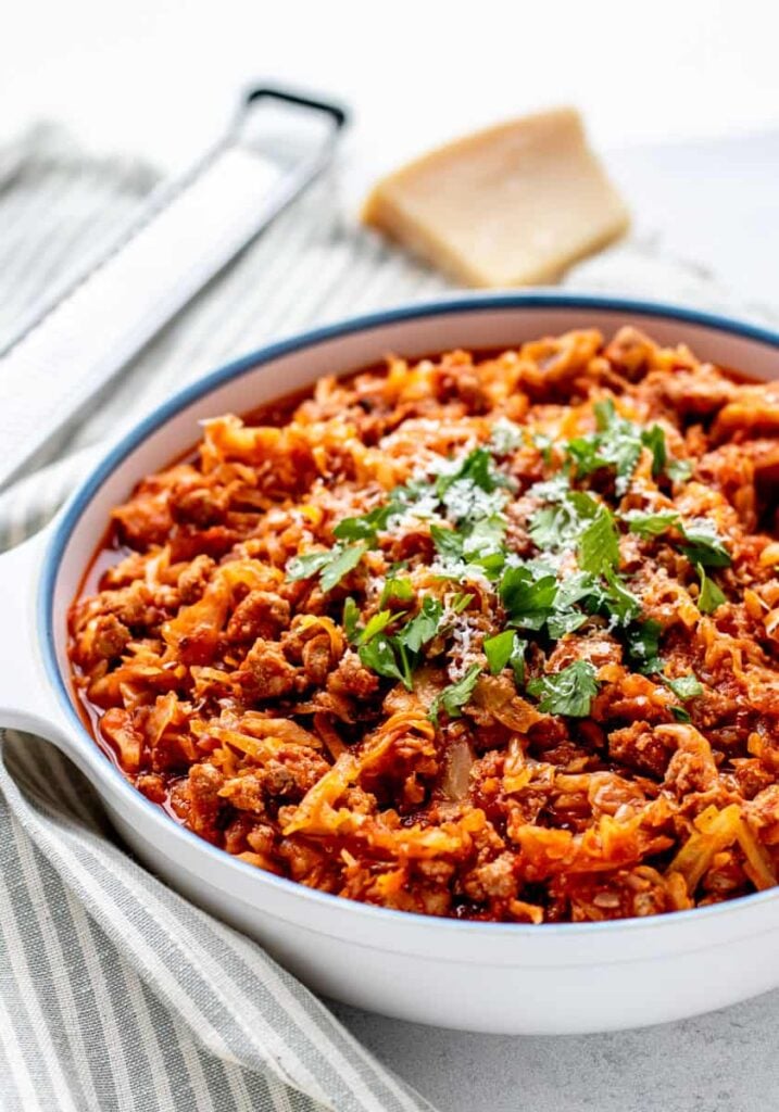 A big bowl of slow cooker cabbage and sausage on a table.