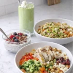 Three high fiber bowls on a counter next to a green smoothie in a kitchen.
