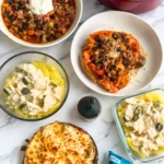 Multiple different meals on a counter: a pot of chili, a bowl of chili, a sweet potato stuffed chili, jalapeno popper shredded chicken over spaghetti squash, and a chicken flatbread next to a bagged salad.