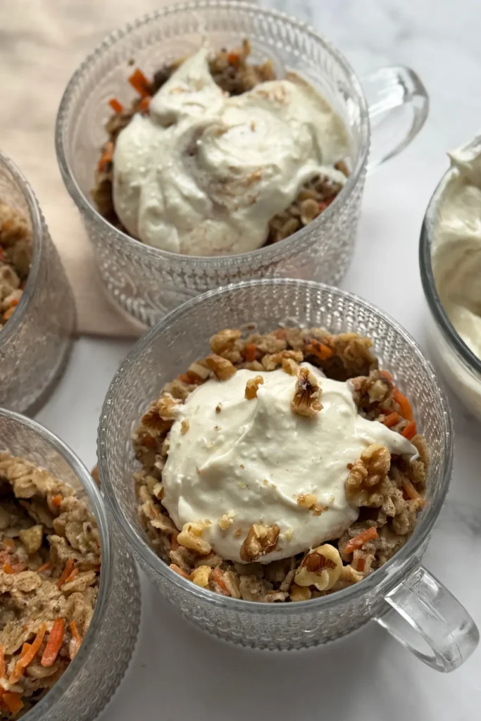 Oatmeal bowls topped with the Greek yogurt frosting on a table.