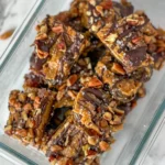 Sliced maple pecan date bars piled up in a glass container.