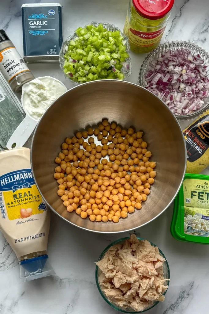 Portioned out ingredients for the chickpea and chicken salad on a counter. 
