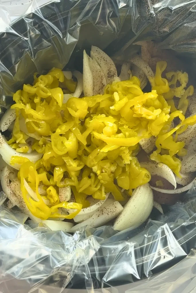 All of the ingredients for the slow cooker pepperoncini chicken in the crockot before cooking.