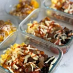 Three savory breakfast bowls next to two sweet mango yogurt bowls on a counter with hot honey and hot sauce.