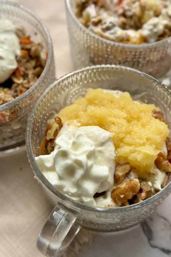 Three carrot cake pineapple loaded oatmeal bowls on a table.