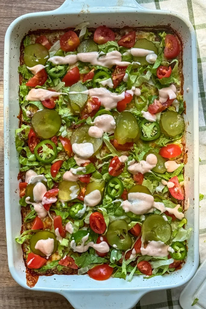 A birds-eye view of a fully assembled cheeseburger lentil casserole in a baking dish on a counter.