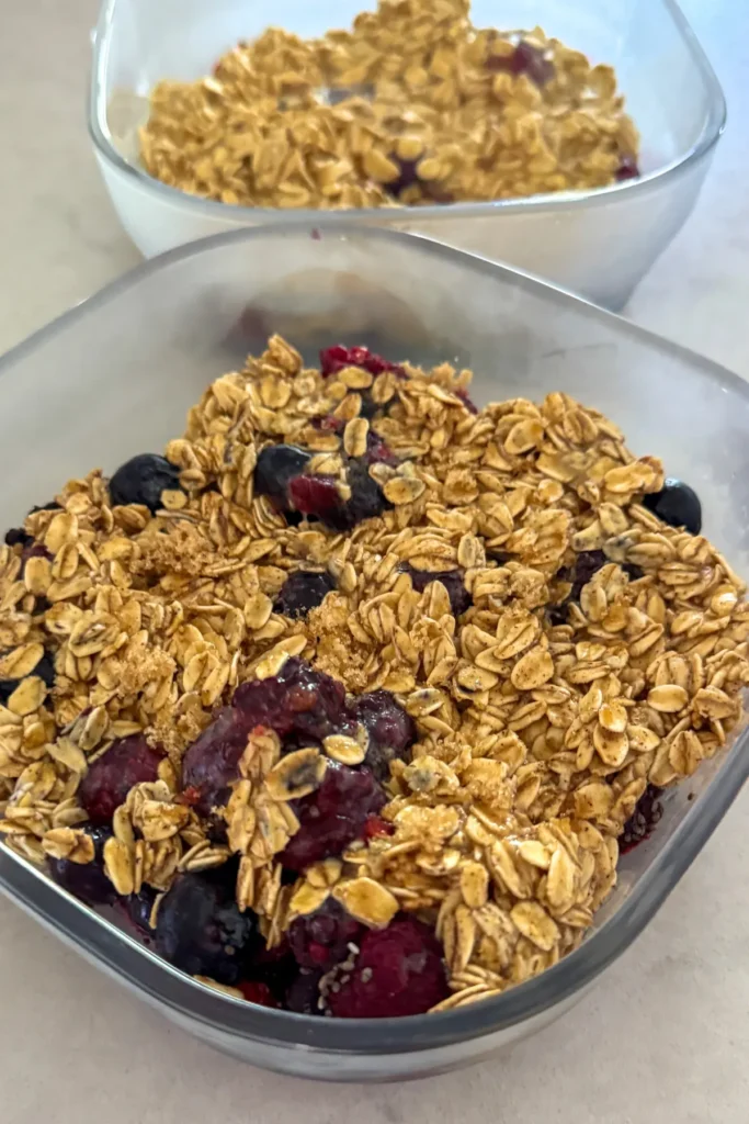 The oat topping added to the meal prep containers before going into the oven.