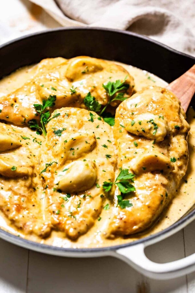 A pan with creamy garlic chicken in it on a table.