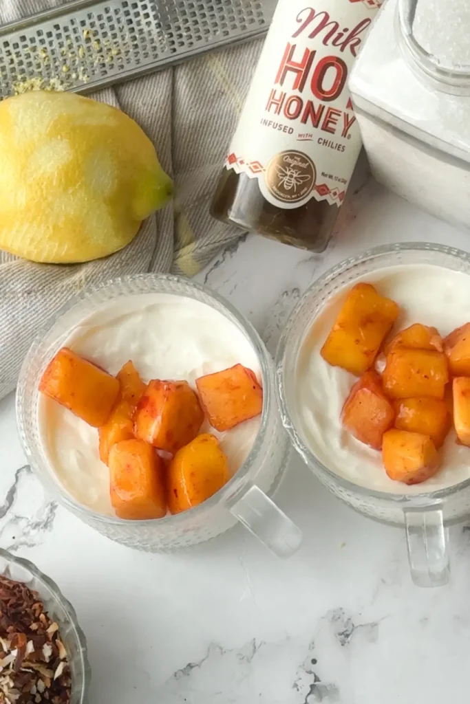 Assembling the yogurt bowls by adding mango on top.