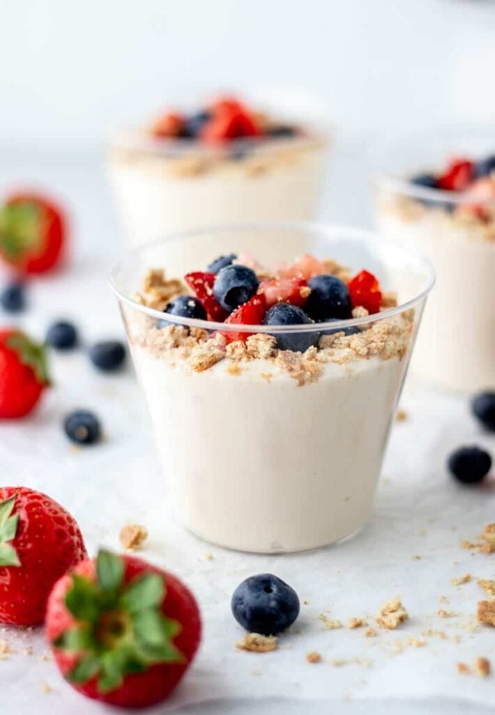 Small berry cheesecake cups on a counter.