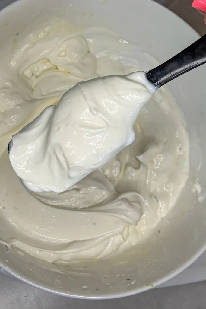 A spatula showing the texture of the Greek yogurt dip after using the immersion blender.