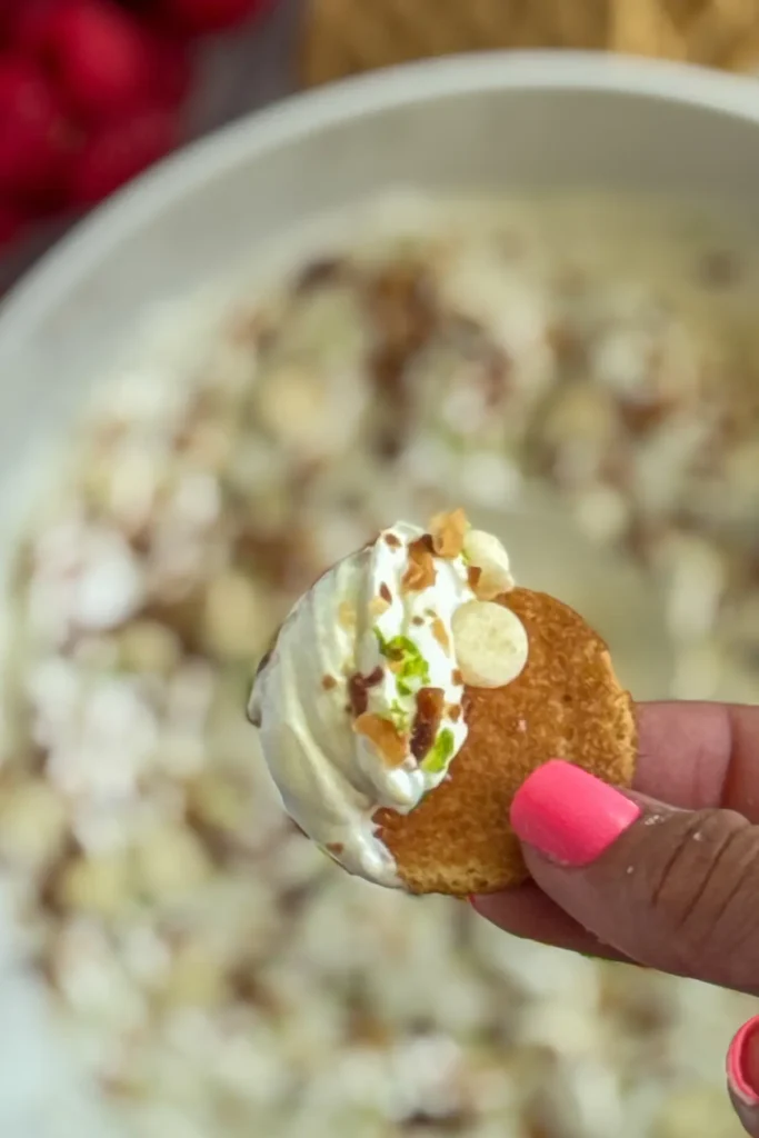 A close-up of a vanila wafer with key lime pie dip on it with the background blurred.