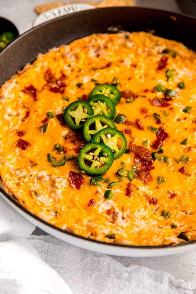 A jalapeno popper dip topped with jalapenos on a counter.