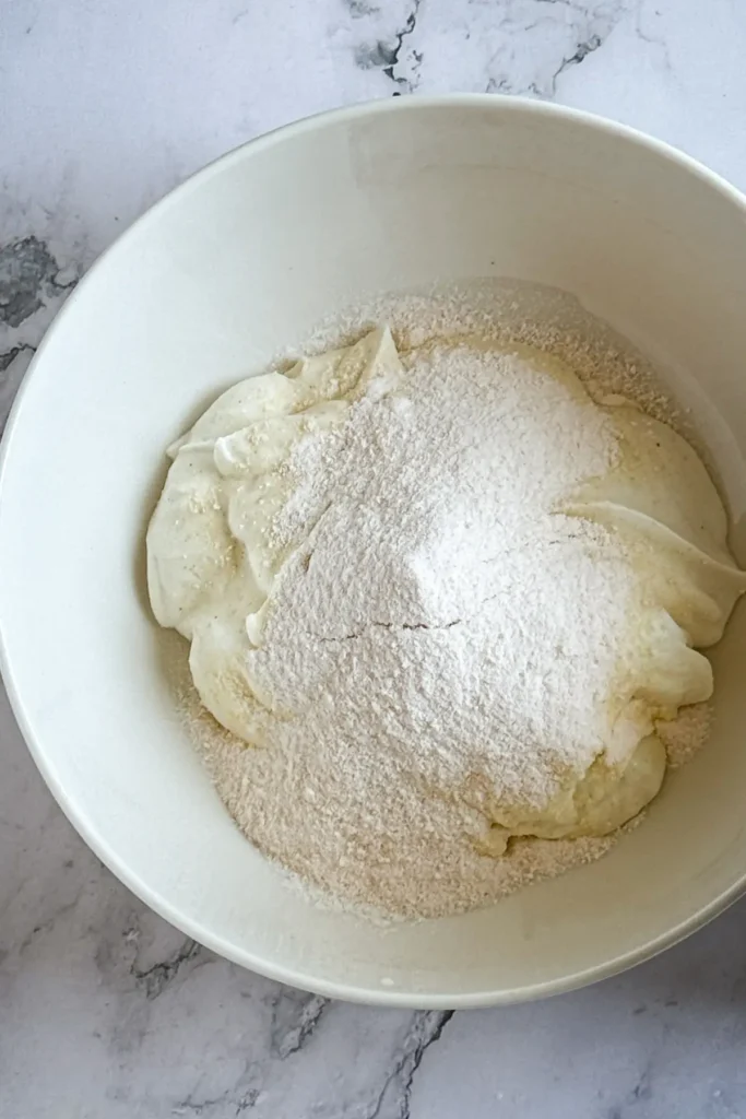 The pudding mix and yogurt in a large white bowl.
