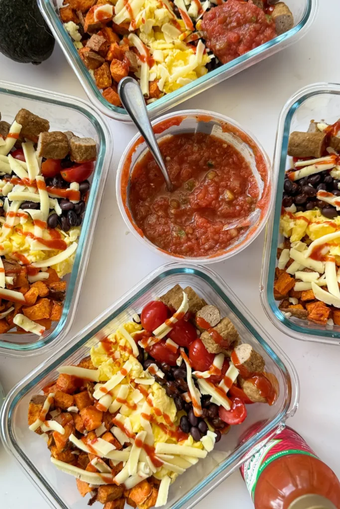 A birds-eye view of four assembled sweet potato and egg breakfast bowls with salsa in the middle.