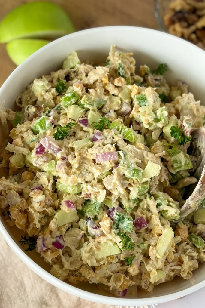 A close-up of a large bowl of apple honey mustard chicken salad.