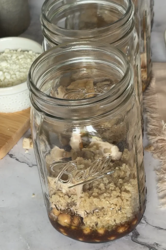 Salad jars with the dressing on the bottom, chickpeas, and then the quinoa.