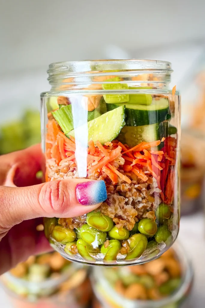 Someone holding up a meal prep salar jar in their hand.